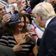 Republican presidential candidate Donald Trump (R) autographs the chest of a woman at his campaign rally in Manassas, Virginia December 2, 2015. Republican presidential front-runner Trump said on Wednesday his plan for combating Islamic State militants involves targeting not just the group's fighters but also their families.